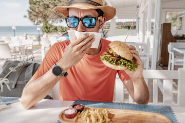 Man disgusted by burger, possibly due to food poisoning or spoiled ingredients in restaurant meal