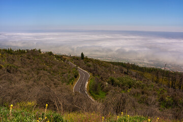Curved mountain road under clouds