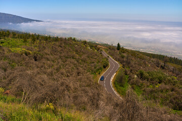 Curved mountain road under clouds