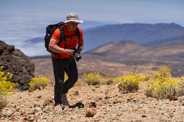 Hiker photographer on volcanic slope
