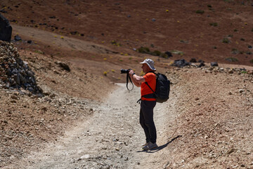 Hiker photographer on volcanic slope