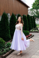 woman in a long purple dress in the park she has curly hair