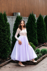 woman in a long purple dress in the park she has curly hair