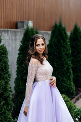 woman in a long purple dress in the park she has curly hair