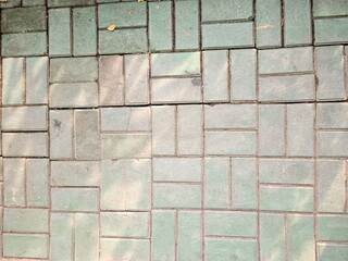High-angle view of patterned concrete paving blocks, ideal for urban infrastructure design or...
