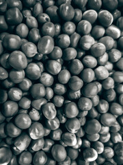 A close-up of freshly picked green peas in an altered gray colour.