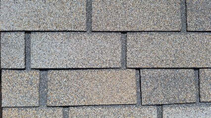 Close-up of gray asphalt shingle roof with textured surface patterns