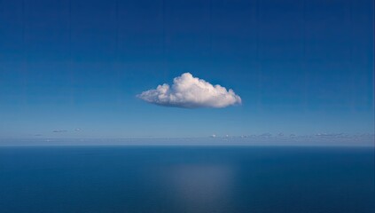 Single cumulus cloud over vast, tranquil ocean
