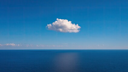 Single, puffy white cloud against a vast, deep blue ocean and sky