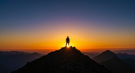 Fototapeta premium A lone figure silhouetted against a vibrant sunrise atop a mountain peak, overlooking a vast, hazy landscape