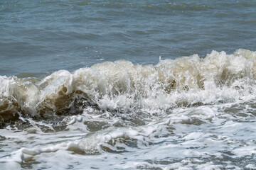 Sea water splashing over the stones on the beach