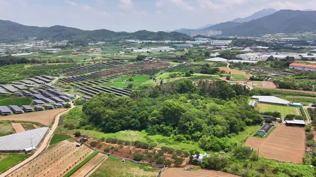 It was taken on July 3, 2025 in ui-rii, Apo-eup, Gimcheon, Korea. This drone footage shows a private solar power plant, surrounding farmland, village houses, and rolling country scenery.