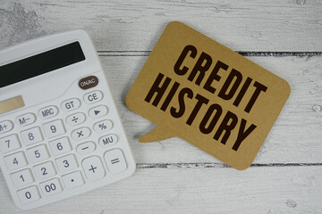 Credit History text with calculator on wooden background
