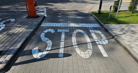 Traffic stop marking on a paved street near a crossroad