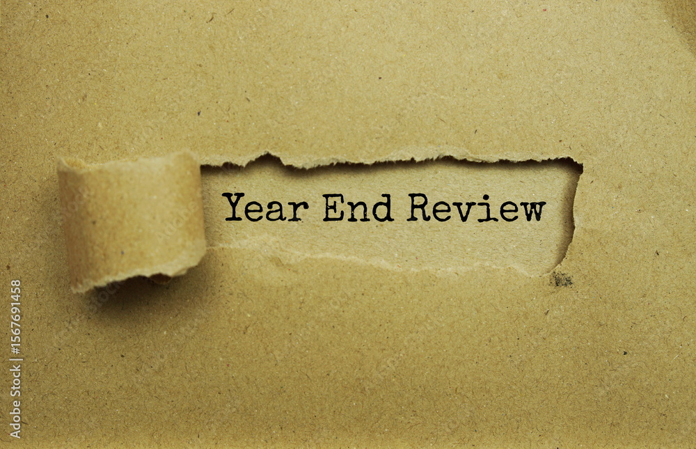 Poster year end review message written on craft paper with torn paper background