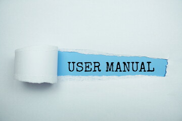 User Manual message written on blue paper with torn paper background