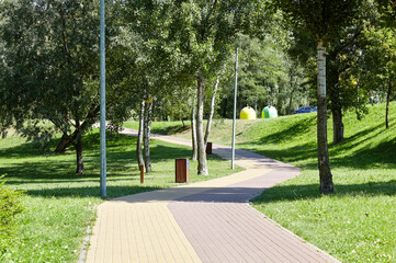 Walkway surrounded by trees and lawns in Kyiv, Europe. Recreation place in the city park