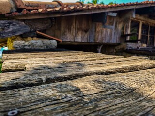 A wooden structure with a roof and a wooden floor. The floor is made of wood and has a rustic look