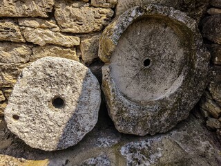 Two large stone circles are sitting next to each other. One of the circles has a hole in the...