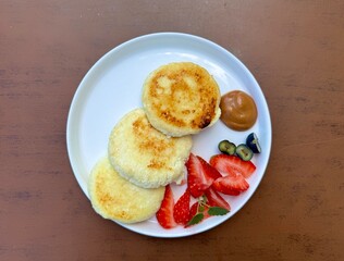 delicious cheesecakes with juicy strawberries for breakfast in a summer cafe. High quality photo