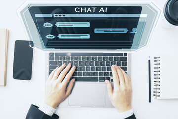 Businessperson using chatbot AI interface on laptop with futuristic digital elements above keyboard...