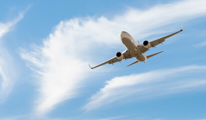White passenger airplane flying in the sky amazing clouds in the background - Travel by air transport