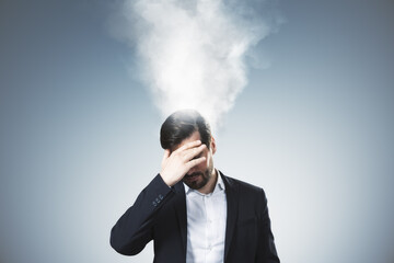 Frustrated businessman under pressure with steam coming from head symbolizing stress and burnout in...