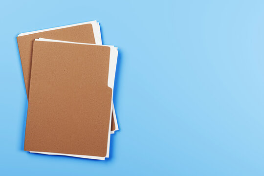 Brown file folders with blank white documents on light blue background, top view with empty space for business or office branding concept. 3D Rendering
