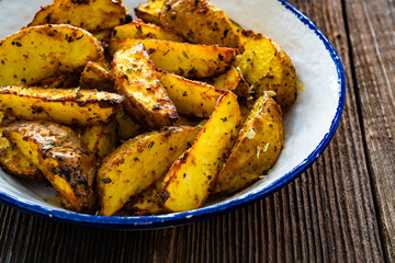 Roasted potatoes on wooden table	