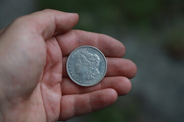 Old American silver coin one dollar in hand