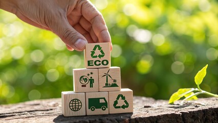 Hand stacking wooden blocks with eco symbols representing sustainability and green initiatives in nature