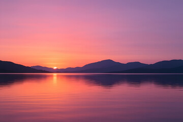 Fototapeta premium Serene Sunset Over Mountains: A picturesque sunset paints the sky in vibrant hues of pink and purple, casting a warm reflection on a calm lake nestled amongst majestic mountains.