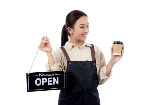 Portrait young asian barista woman wearing apron holding open sign and coffee cup for inviting customer to enter with happiness, waitress woman holding signboard, small business or startup business. - Powered by Adobe