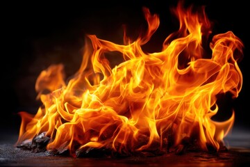 Fototapeta premium Bright flames dance vigorously in an open fire against a dark background