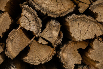 Pile of split firewood, ready for burning. Close-up of weathered wooden planks showing knots and...