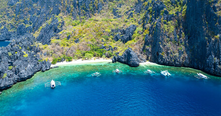 Aerial view of a beautiful tropical island with crystal clear water  with limestone cliffs  as the...