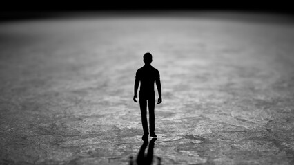 Black and white image representing a silhouette of a man standing on a rough surface. Possibly representing loneliness. Isolation. Or a journey into the unknown. With the figure casting a long shadow