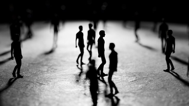 Miniature figurines of people are walking on a reflective surface, casting long shadows in a dimly lit environment, creating a dramatic and mysterious scene