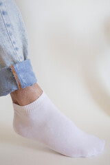 white sock with copy space on human foot close up photo on white background.