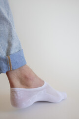 white sock with copy space on human foot close up photo on white background.