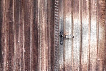 Old vintage wooden door ornate with a beauty metal handle.
