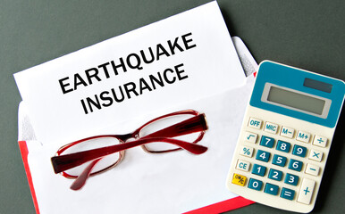 EARTHQUAKE INSURANCE - words on a white sheet of paper with an envelope, calculator and glasses in...