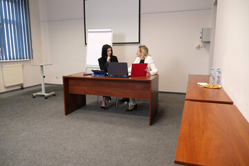 Two women discussing business issues, analyzing information.