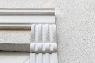 Close-up of architectural decorative element on textured white wall