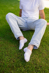 Male foot in white sock on the background of grass. Man foot with sock on.