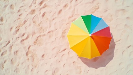 Bright multicolored beach umbrella from above, casting sharp shadows on sand under intense sunlight, summer vacation concept with space for text