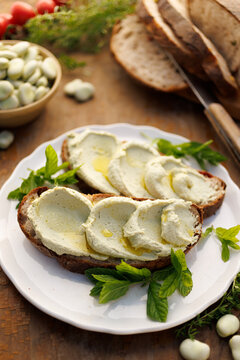 Broad bean spread sandwiches with olive oil on a white plate, close-up view
