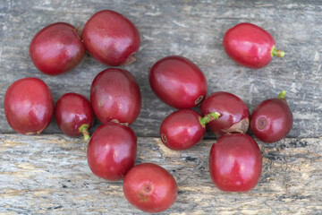 Freshly harvested red coffee cherries on rustic wooden background