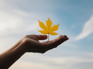 yellow autumn leaf on a hand