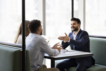 Planning for future. Young couple sit at table with professional legal or financial advisor...